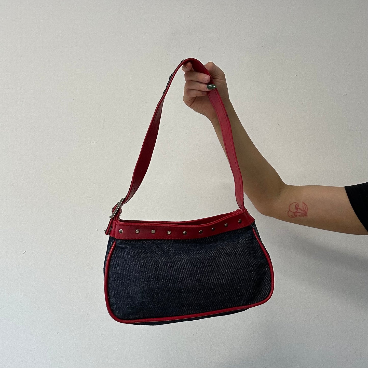 denim and red studded shoulder bag