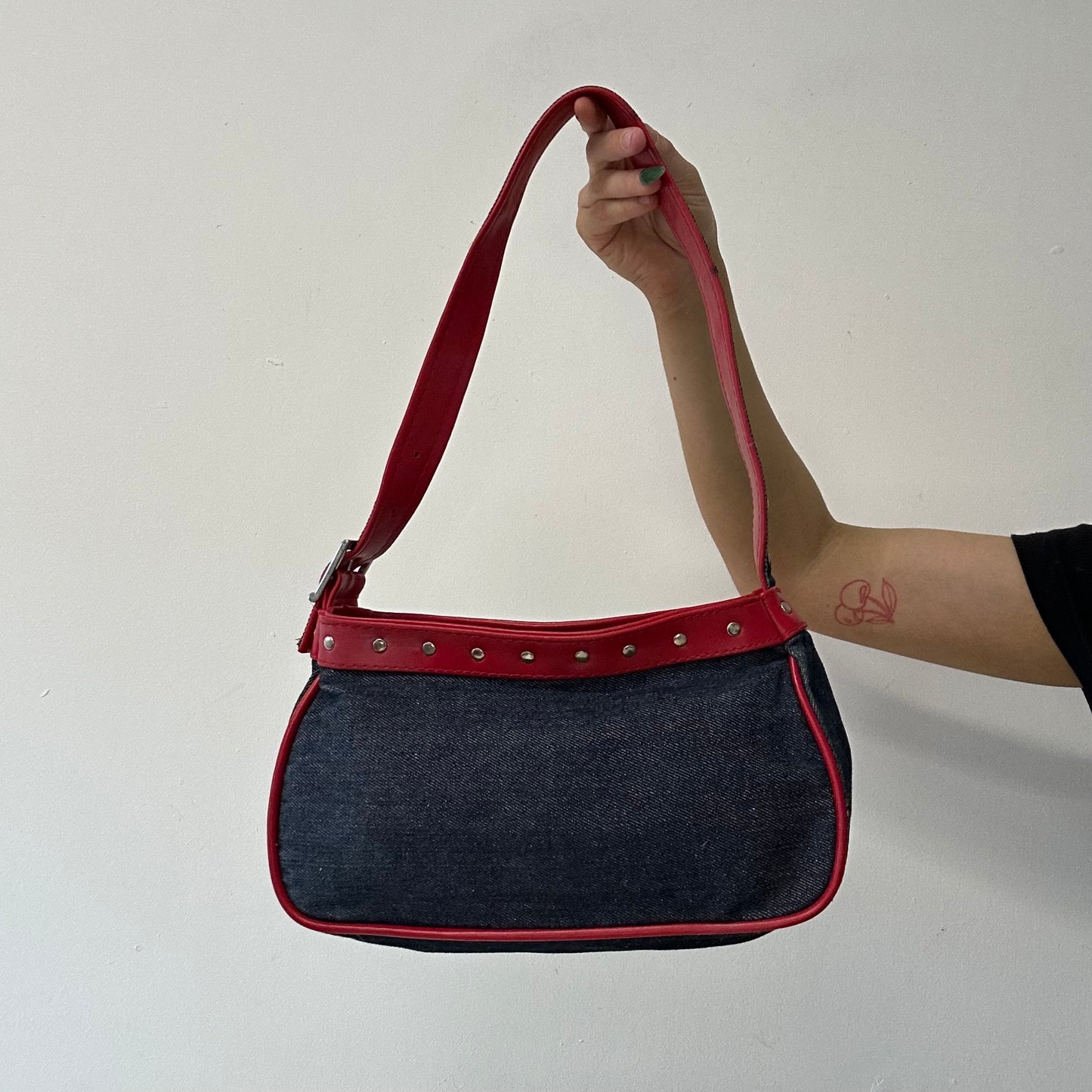 denim and red studded shoulder bag