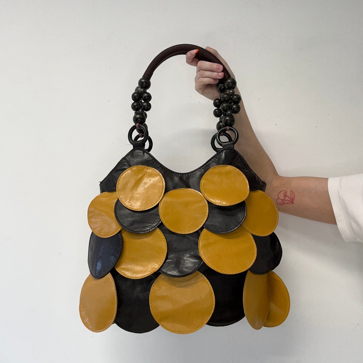 yellow and black faux leather disc beaded shoulder bag