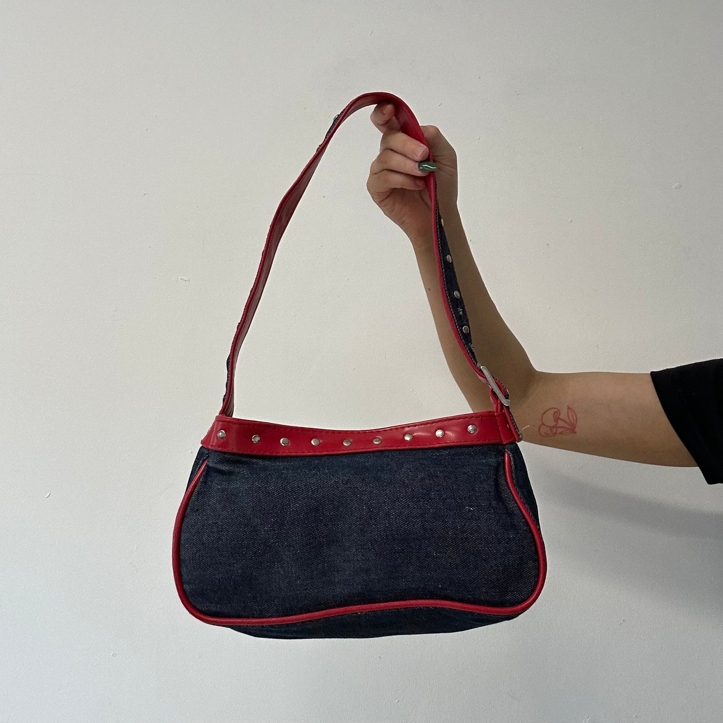 denim and red studded shoulder bag