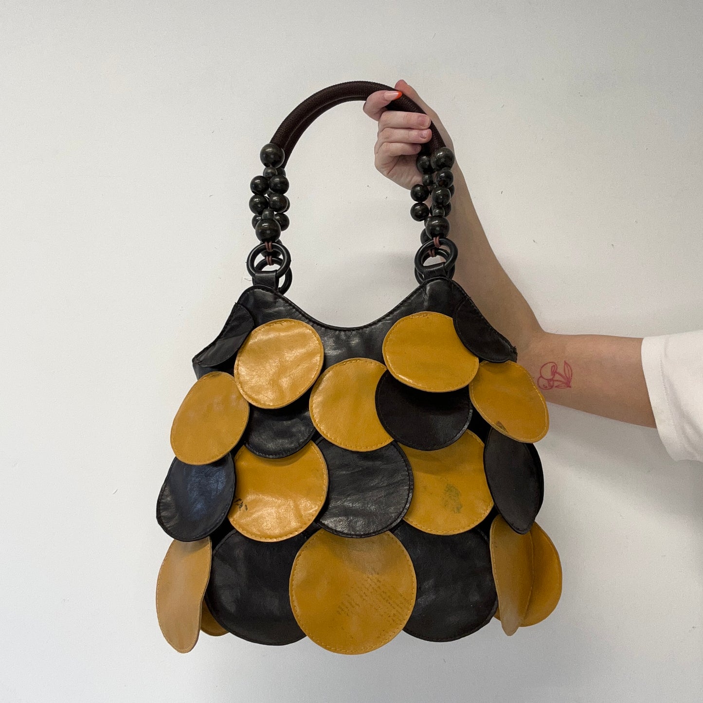 yellow and black faux leather disc beaded shoulder bag