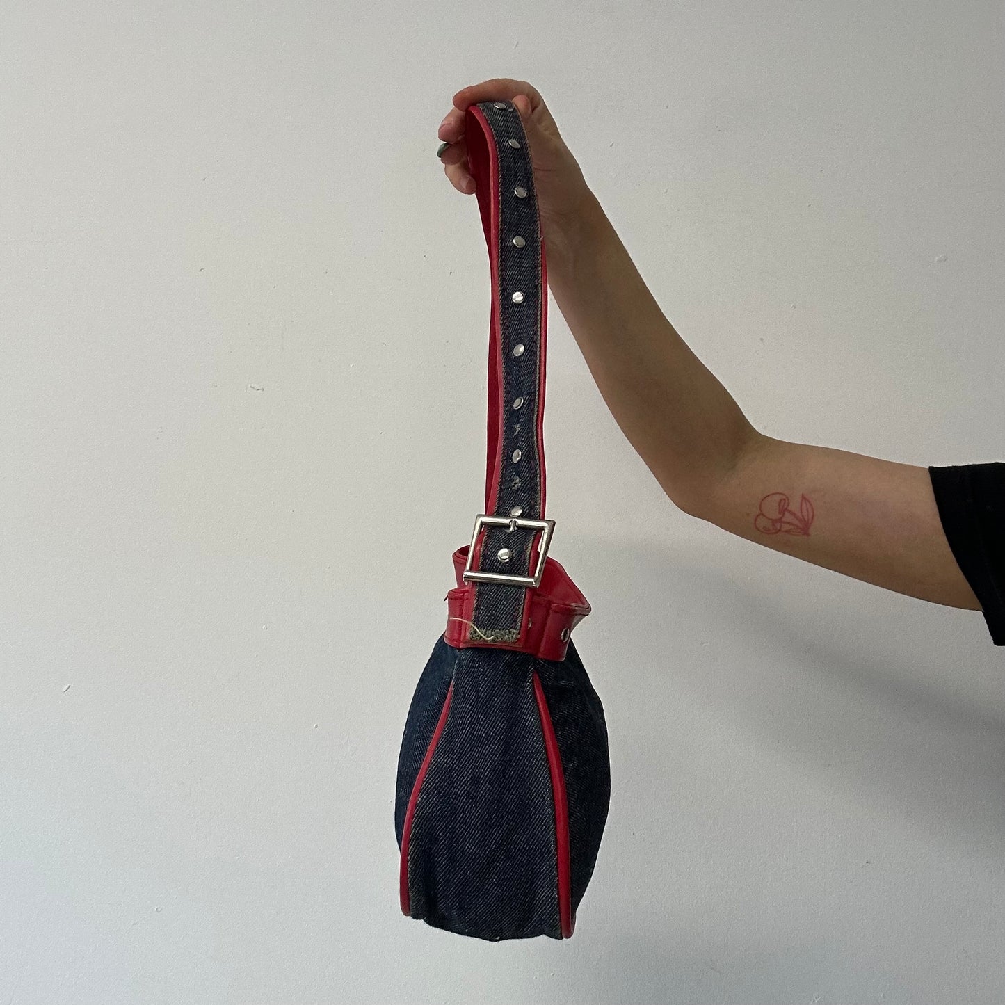 denim and red studded shoulder bag