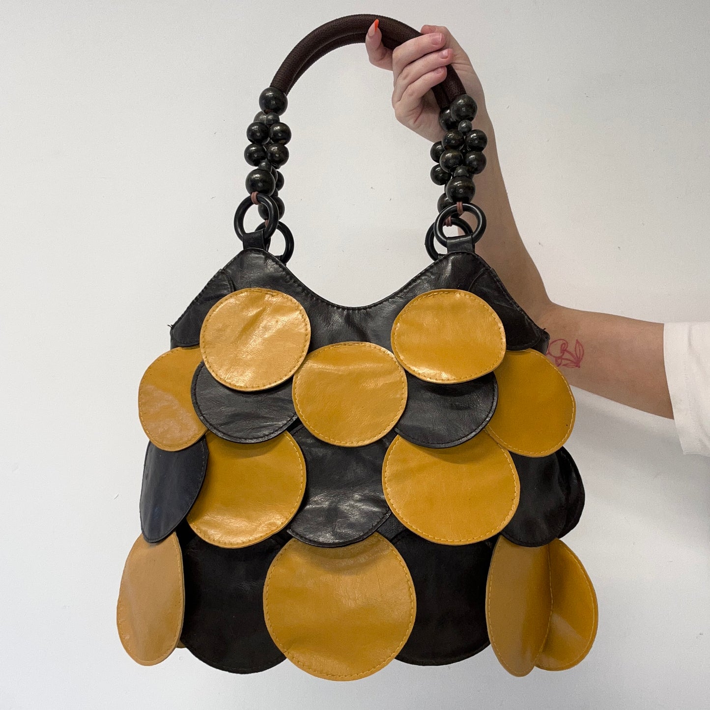 yellow and black faux leather disc beaded shoulder bag