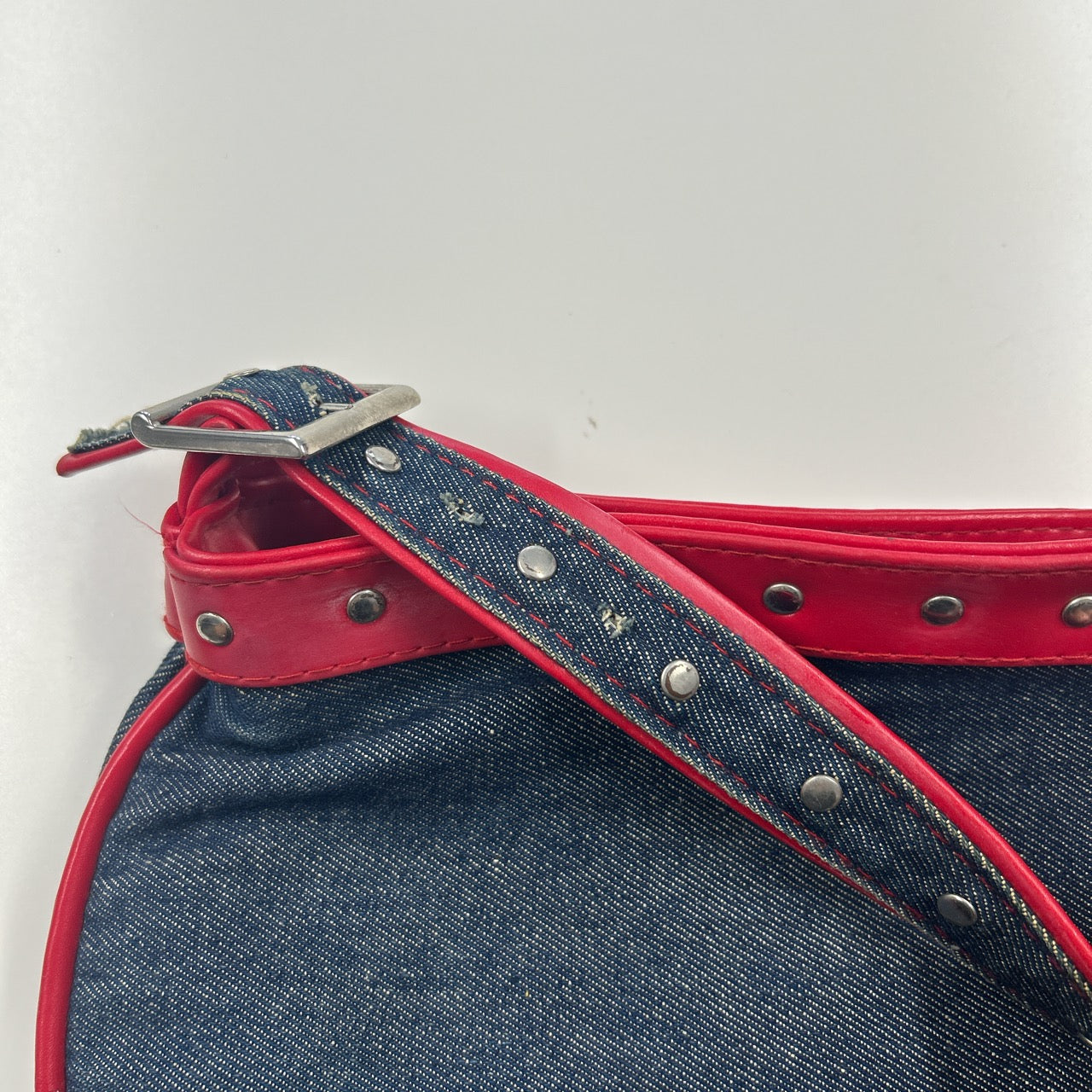 denim and red studded shoulder bag